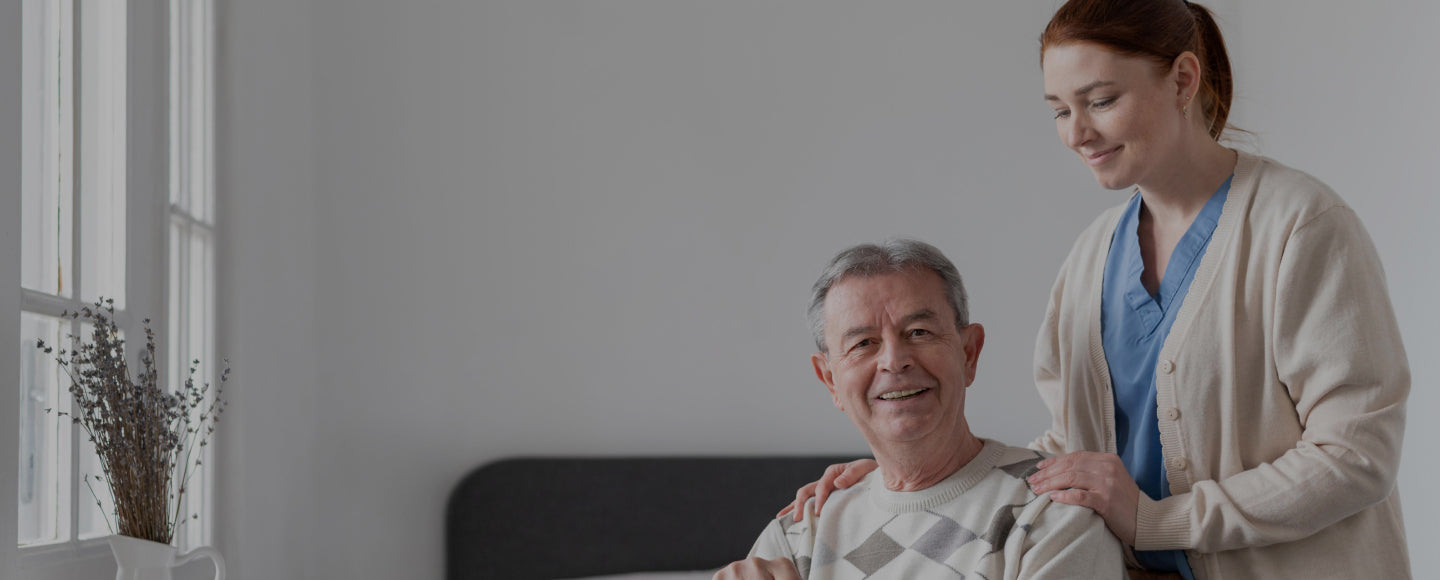 Nurse standing behind an old patient holding him