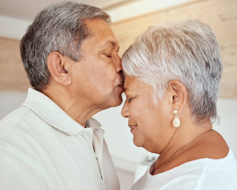 older man kissing wife's forehead