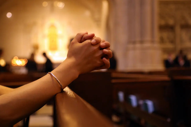woman's hands on church bench