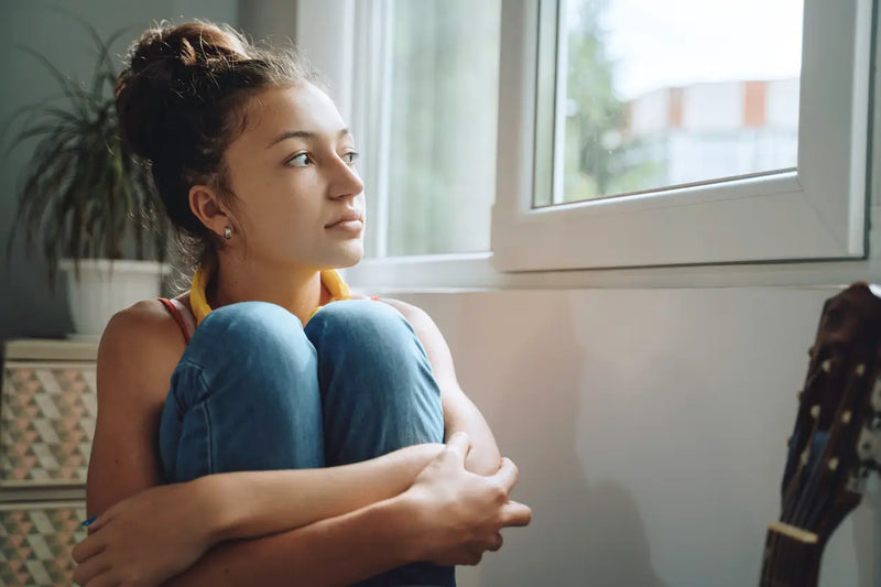 pensive young lady near the window